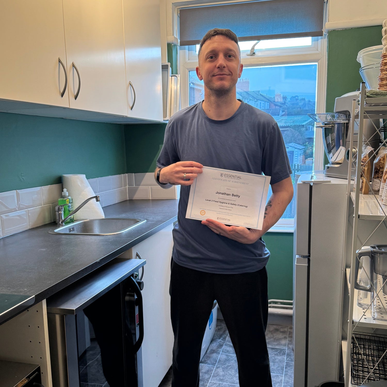 Person holding a certificate in a kitchen