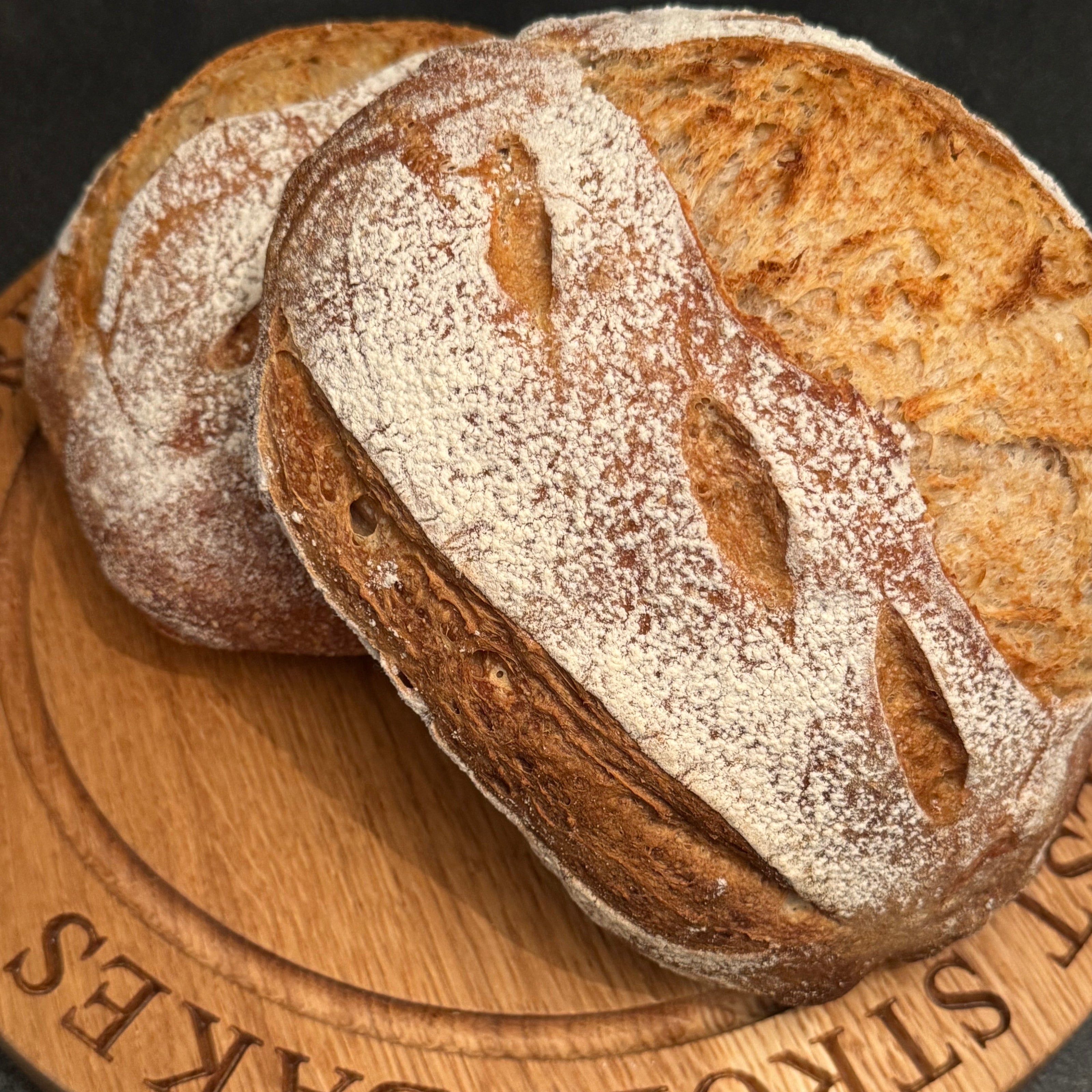 Loaves of bread on a wooden board with 'Forest Stroll Bakes' branding.